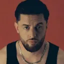 Foto von BAUSA in einem schwarzen Tanktop, wie er in die Kamera schaut